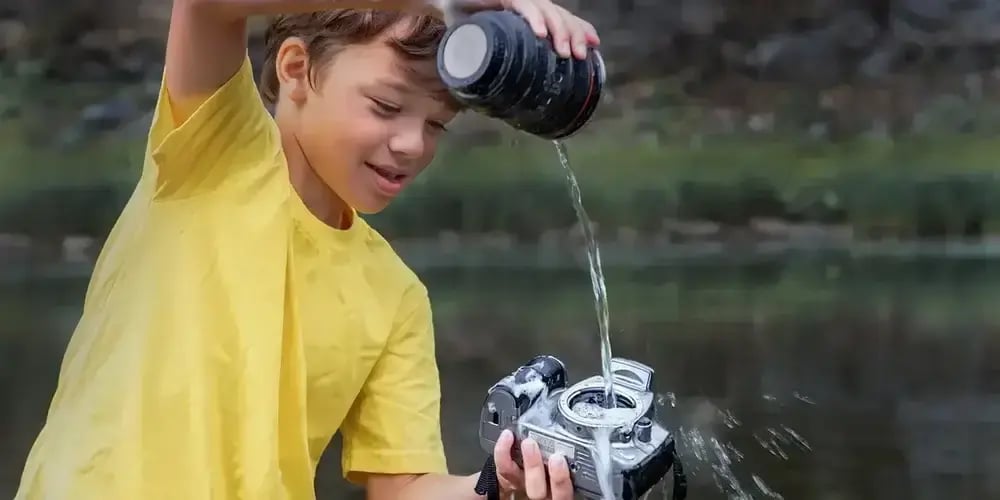 boy pouring water over an HZO Parylene coated camera