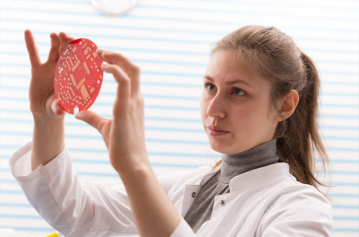 engineer looking at PCB to determine how to best remove conformal coating